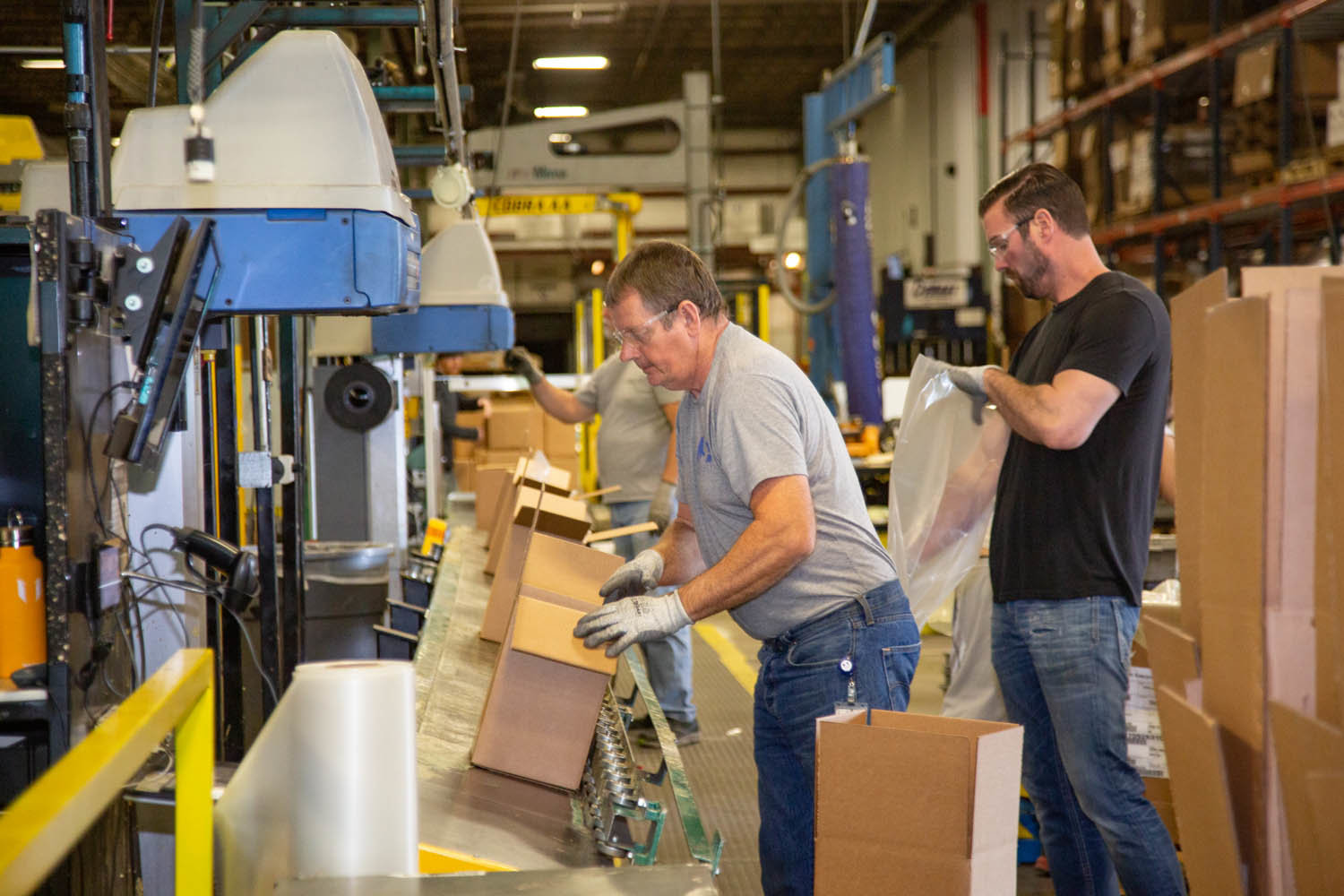 IN OPERATION: NewStream Enterprises workers Mark Lehman, left, and Tad Hutchens package products in the company’s warehouse in the former Solo Cup building.